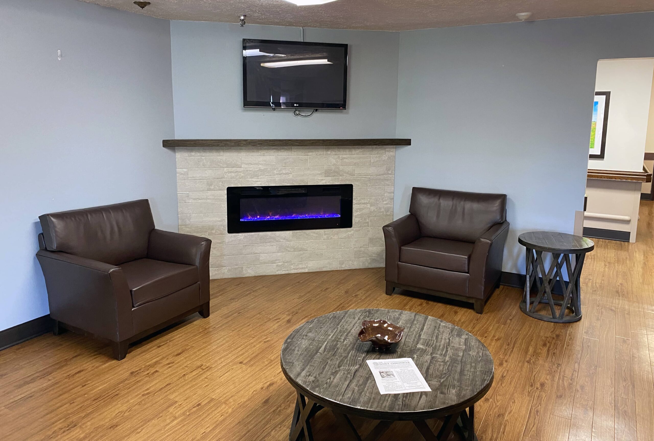 Brickyard Healthcare Churchman Care Center sitting area with fireplace and TV