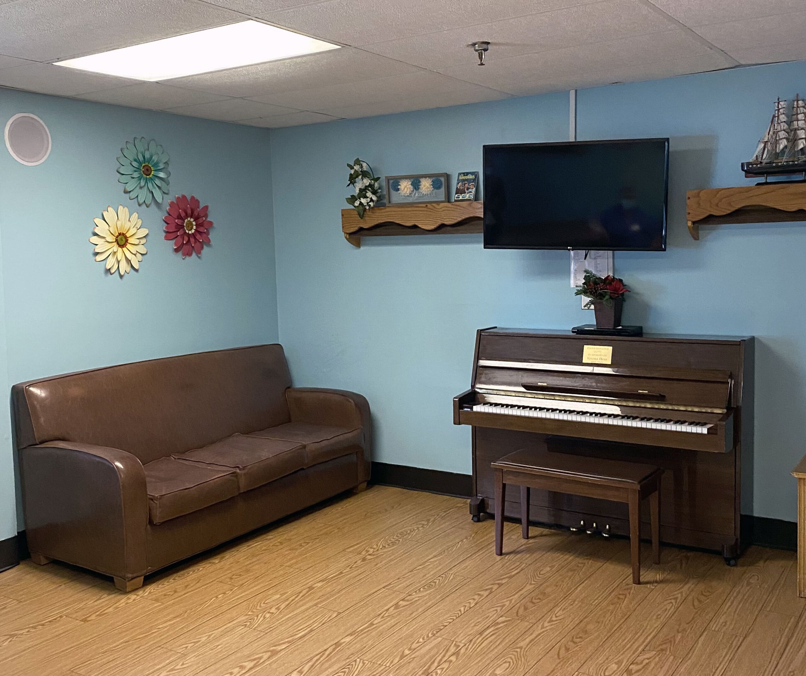 Brickyard Healthcare Sycamore Village Care Center sitting area with TV and piano