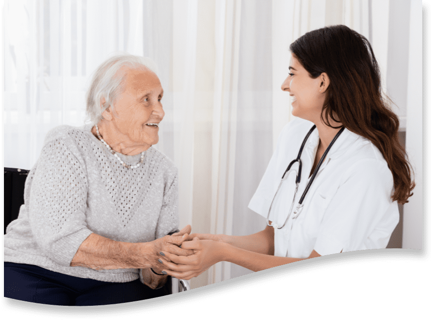 A nurse speaks to a Brickyard Healthcare patient and holds her hand.