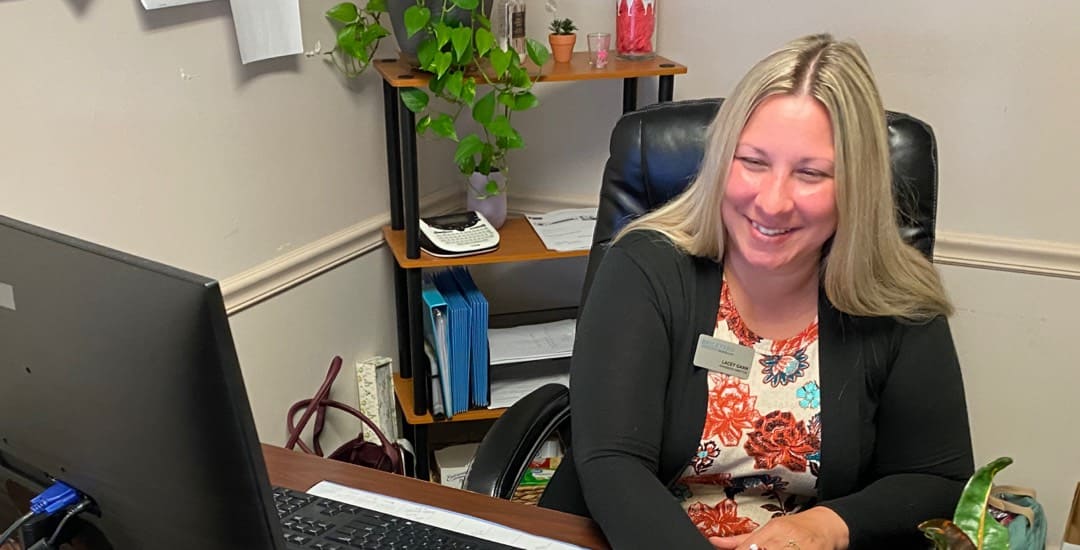 A Brickyard Healthcare team member sits at the front desk of one of our care centers.