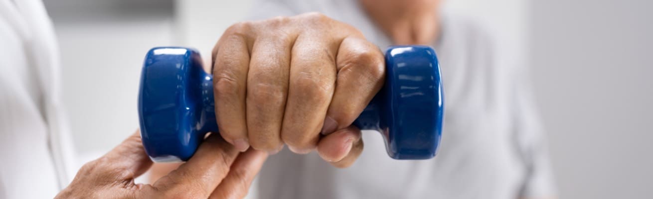 A patient exercises using a dumbbell.