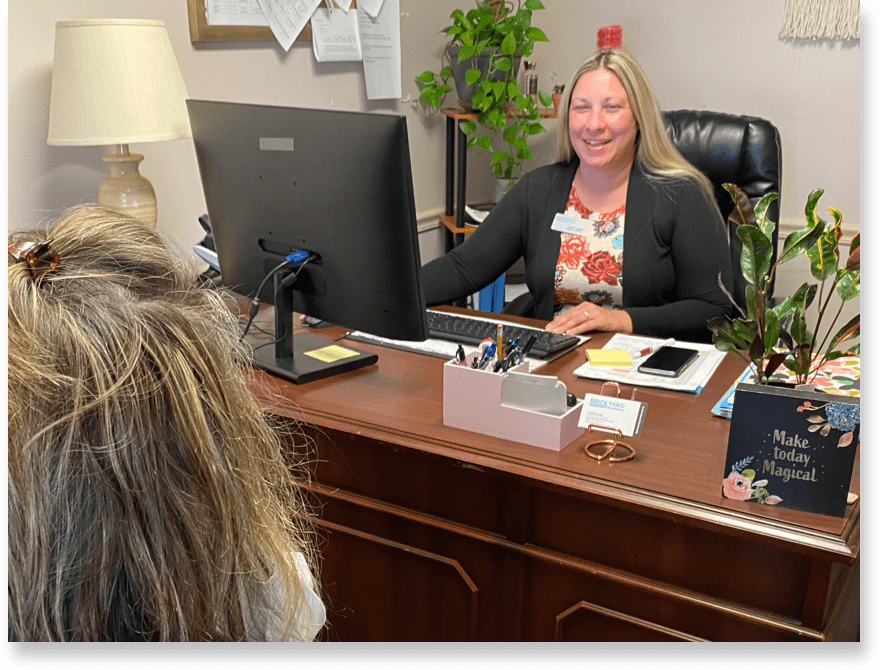 A Brickyard Healthcare team member speaks with a volunteer in her office.